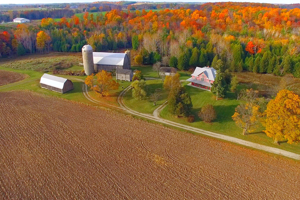 overhead scene of a tilled farm field, house and barn