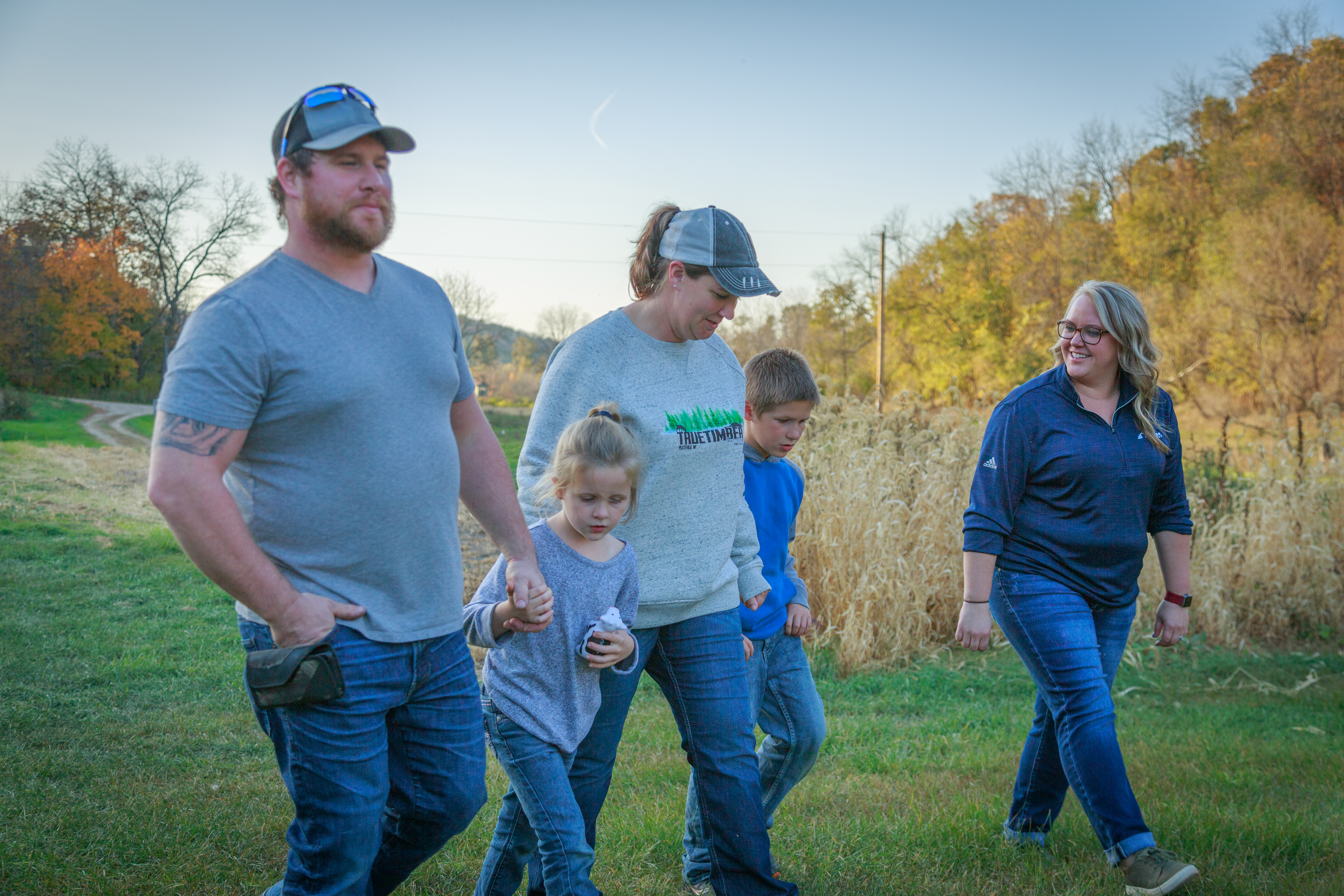 A family happily walking on a path on dream rural property