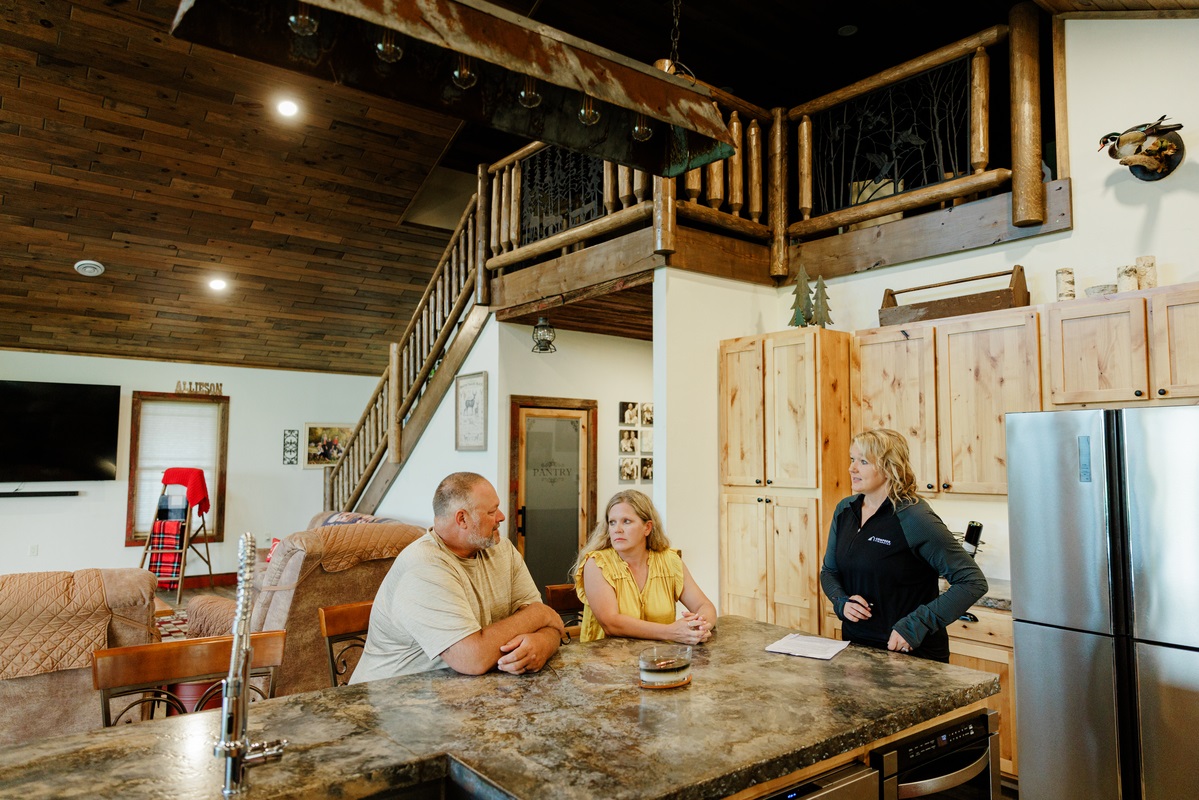 Couple engages in conversation with home advisor discussing tips for homebuyers 