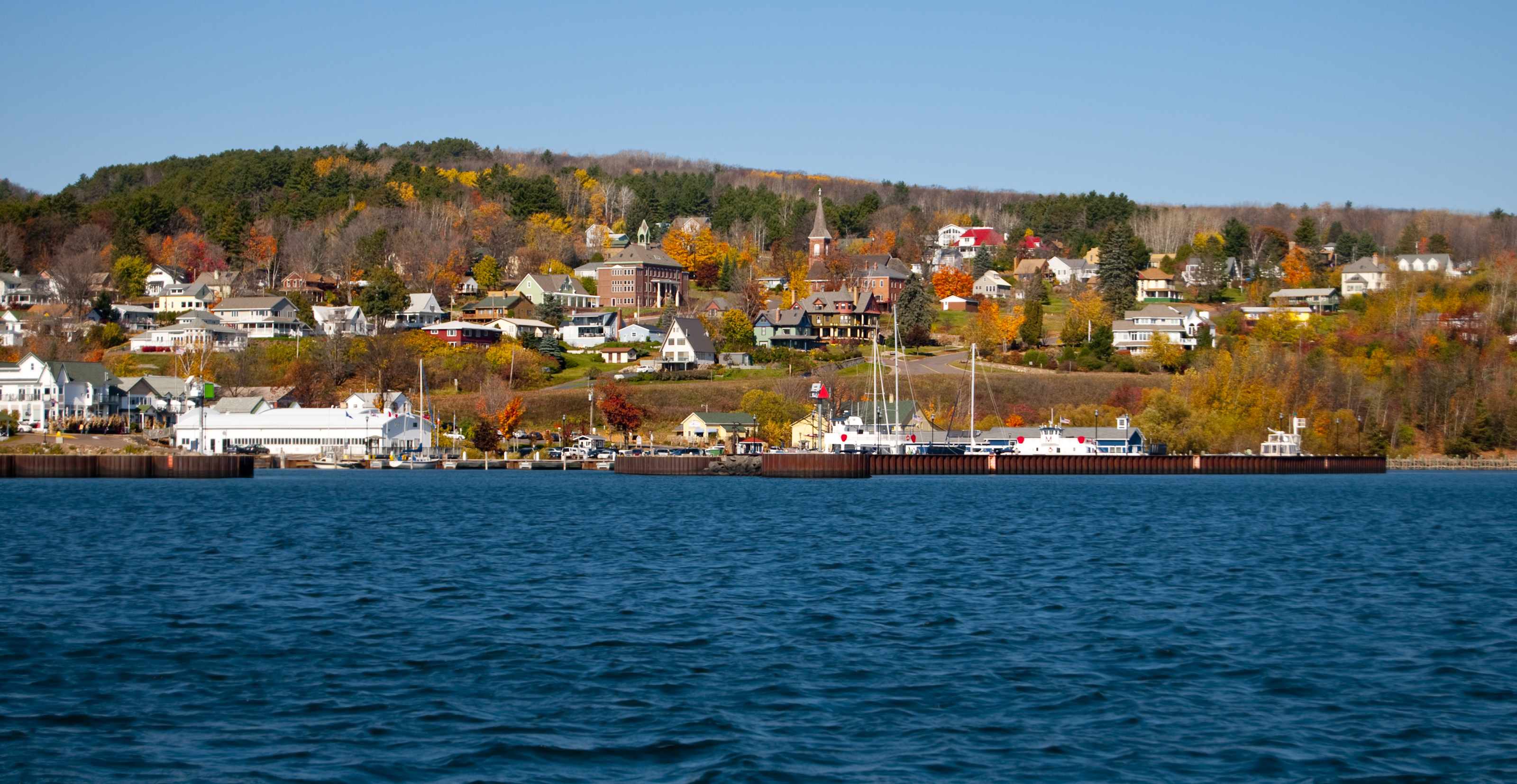 View of Bayfield, Wisconsin with harbor and fall-colored hillside homes.