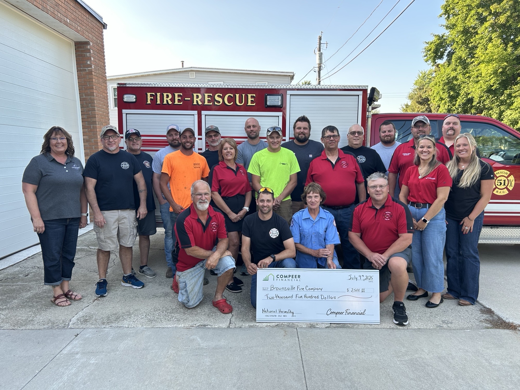 Brownsville Fire Company volunteers and Compeer team members pose with a $2,500 check.