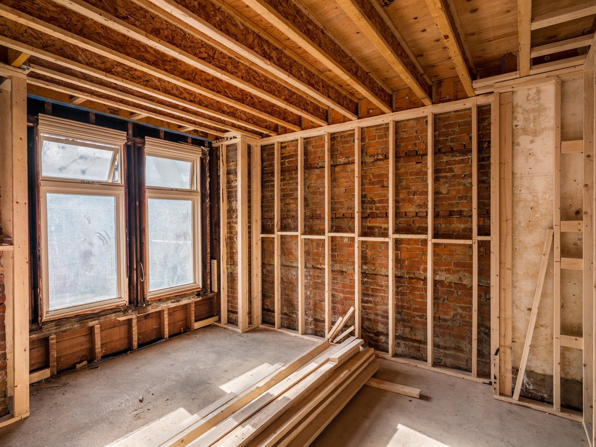 Exposed brick and framing inside a home undergoing interior renovation work.
