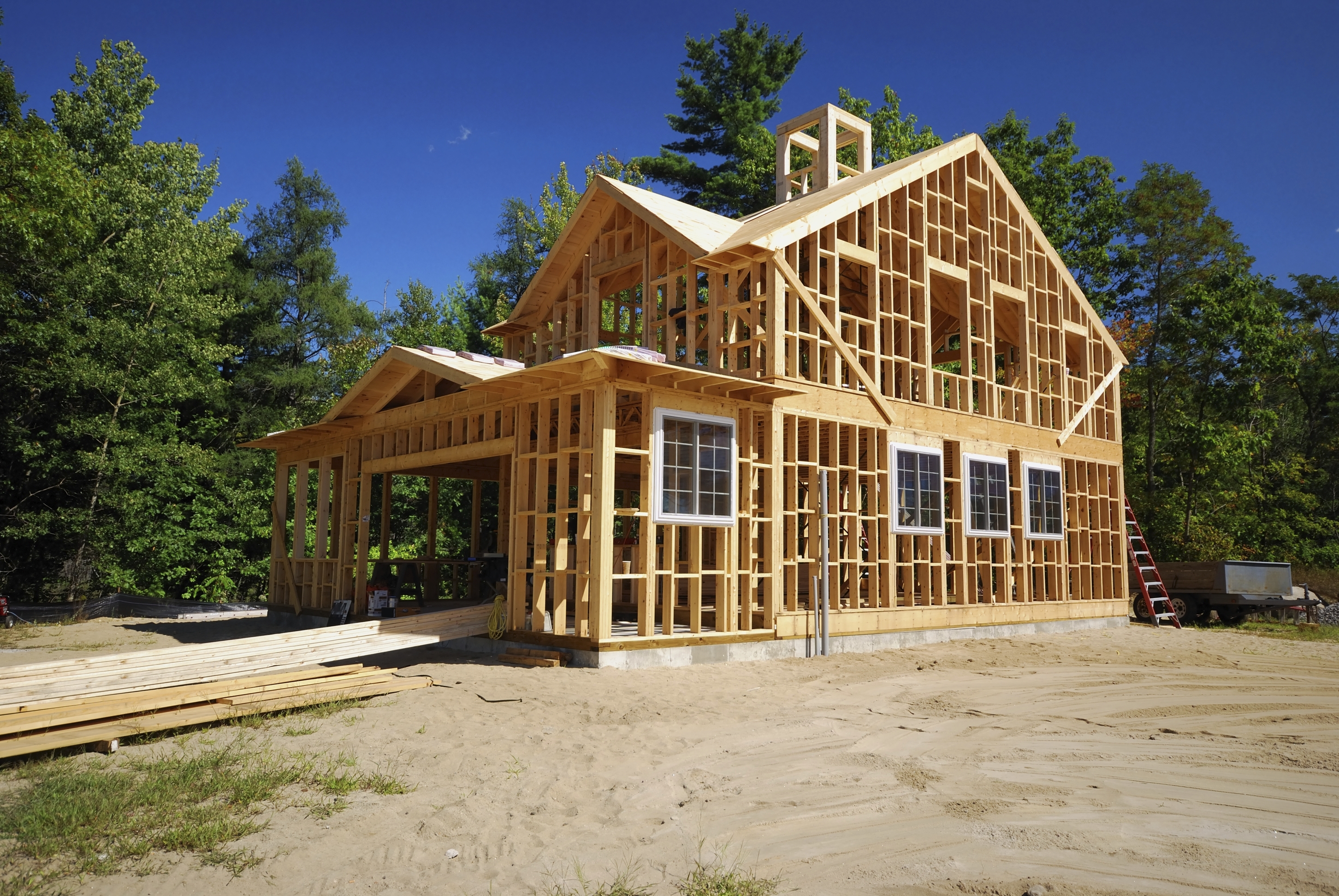 Framed house with lumber on the garage for building
