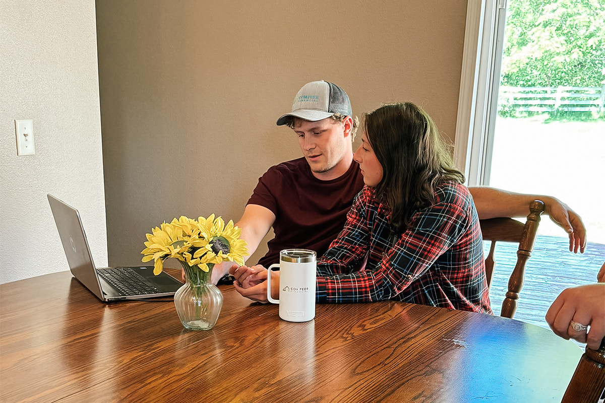 First-time homebuyers sit at a table taking an online homebuyer education course.