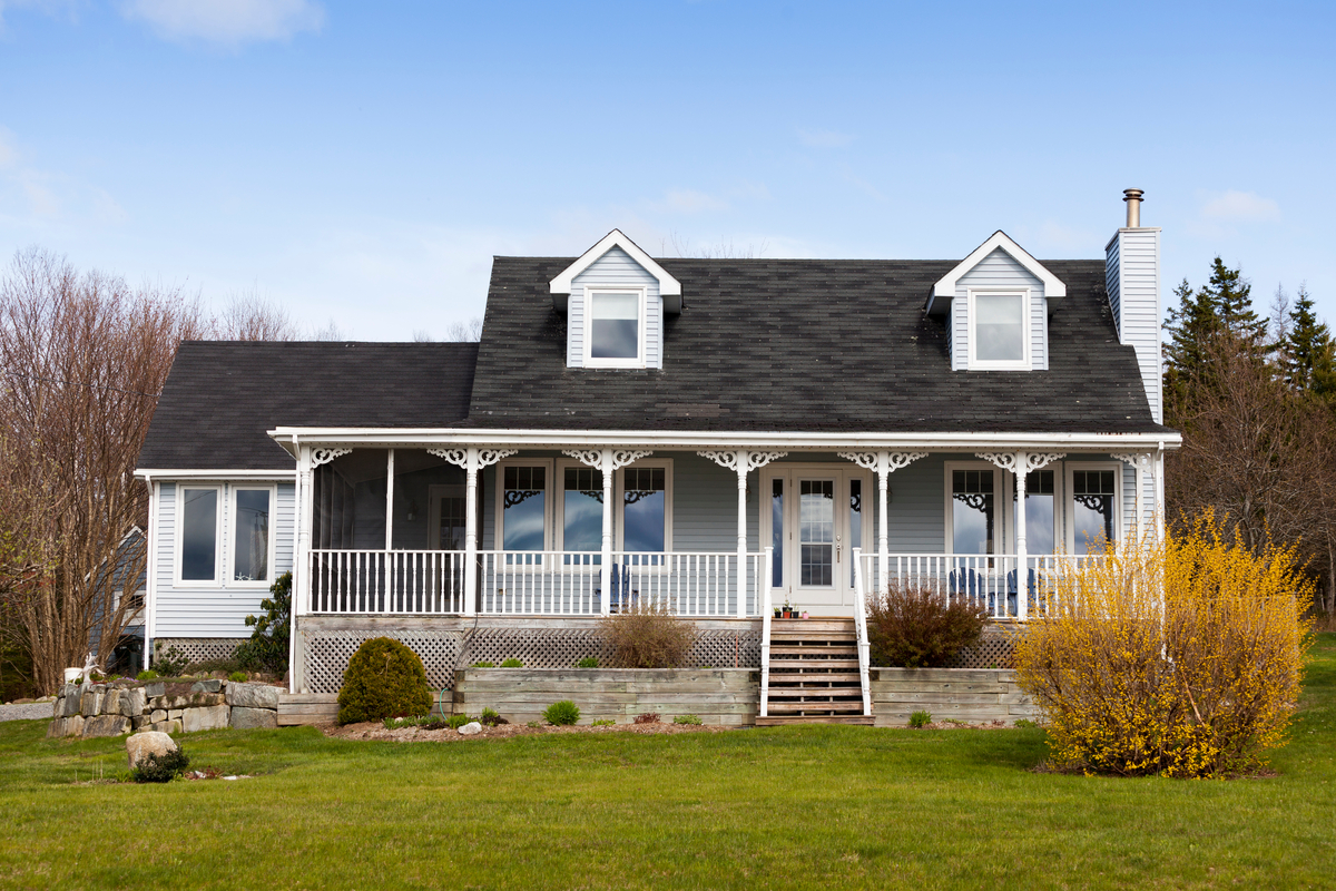 White house and garage on a large grassy field
