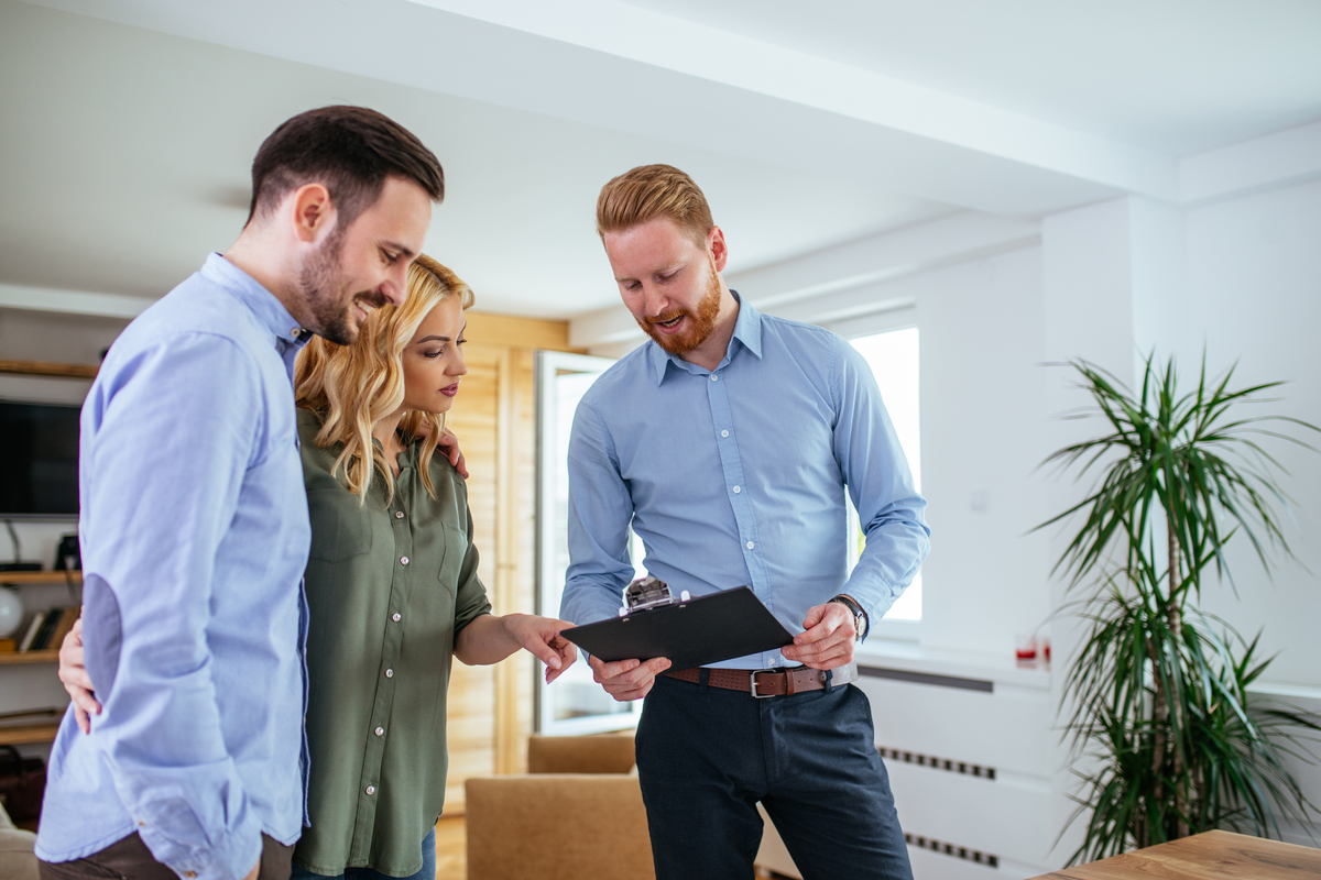 First-time rural homebuyers review paperwork with a loan officer inside their new home.