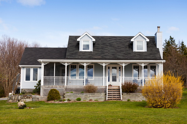 White house and garage on a large grassy field
