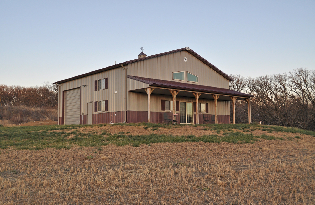 Large beige barndominium on a grassy lot