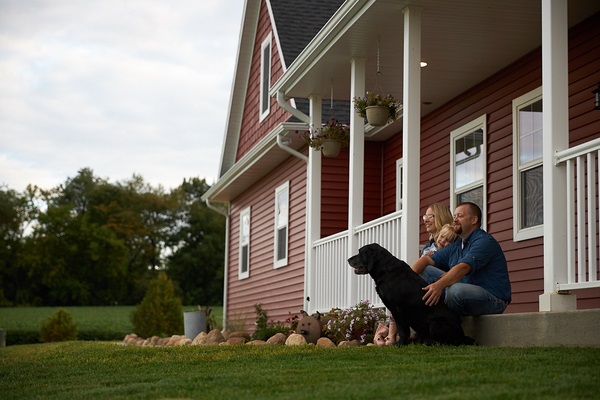 Man and woman holding hands while walking in front of house