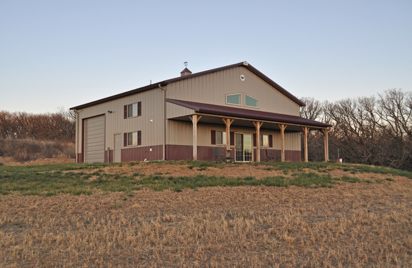 Large beige barndominium on a grassy lot