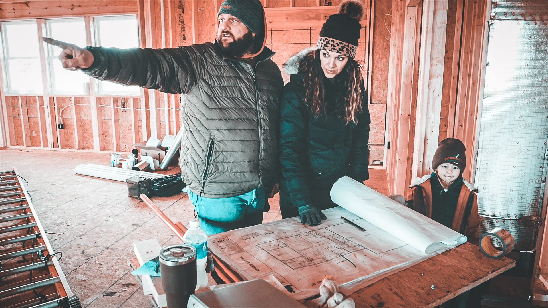 Man, woman, and child talking inside a home under construction